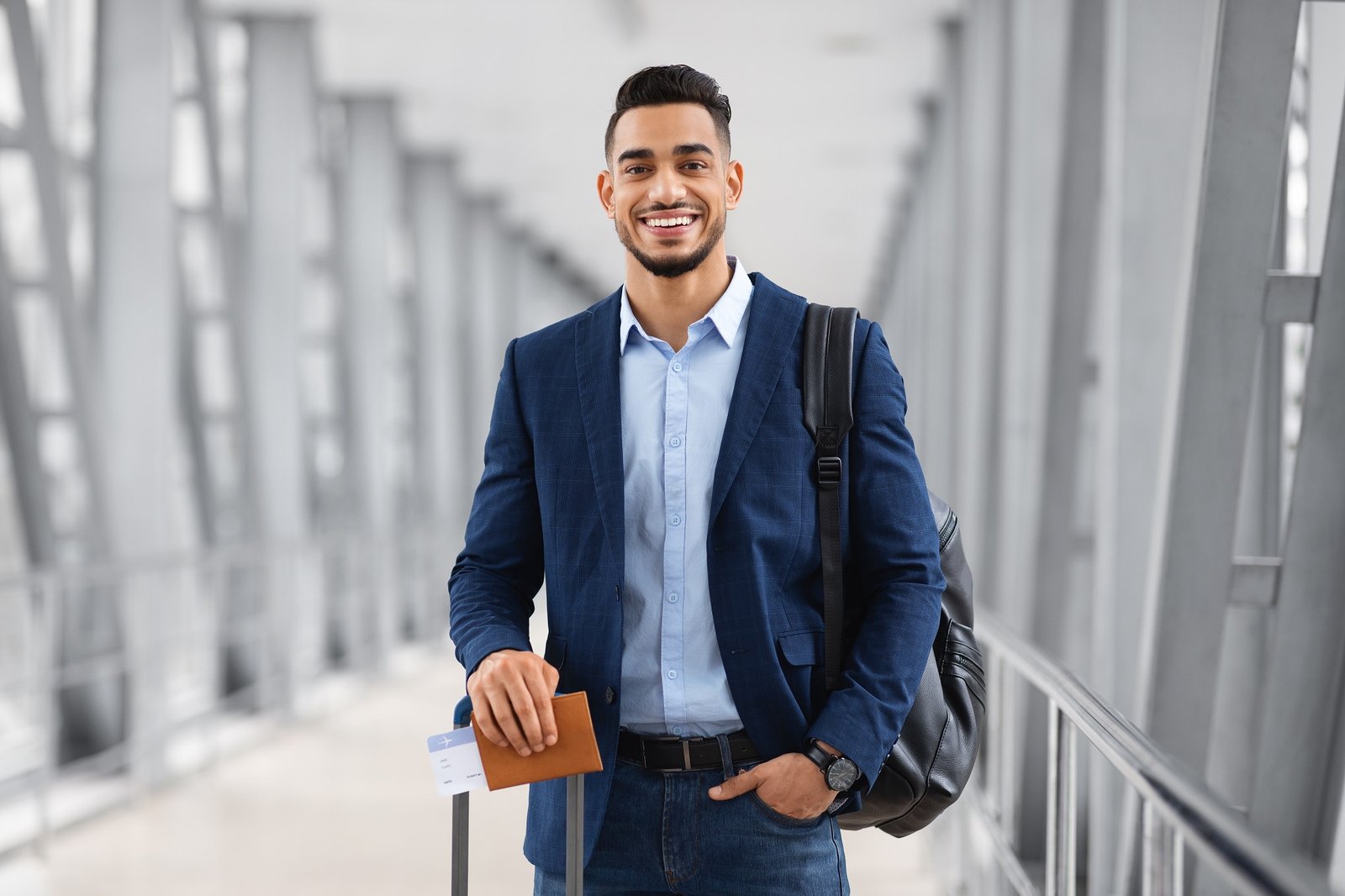 Portrait Of Young Middle Eastern Male Traveller Posing At Airport, Handsome Arab Man With Luggage, Passport And Tickets Smiling At Camera While Waiting For Flight In Terminal, Copy Space